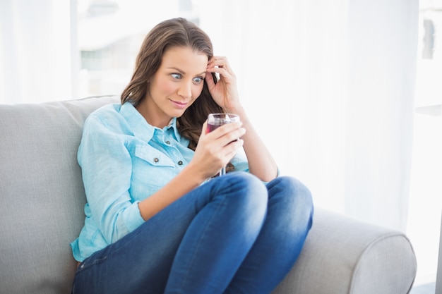 Funny woman looking at her glass of wine