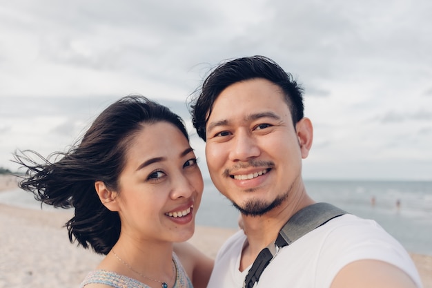 Funny wow face selfie of couple on beach.