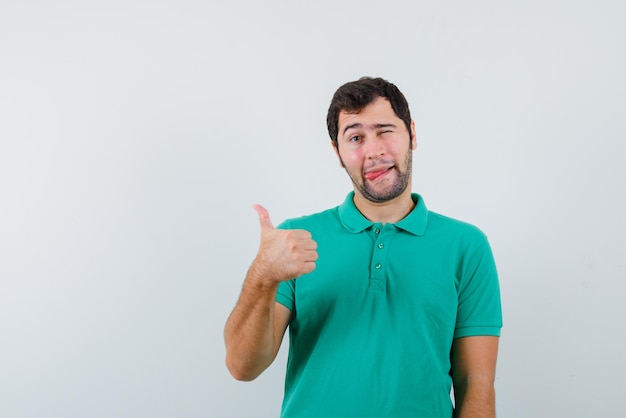 The funny young boy is winking by holding "perfect" sign on white background