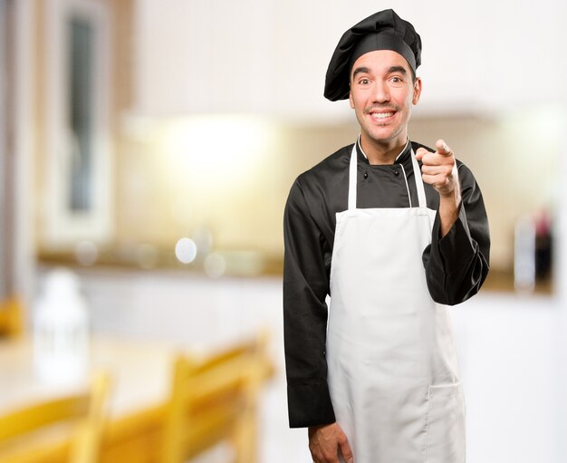 Funny young chef laughing at you