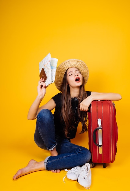 A funny young girl goes on a trip with a big red suitcase keeps plane tickets