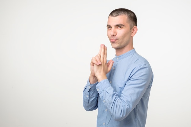 Funny young hispanic man pretending to have gun