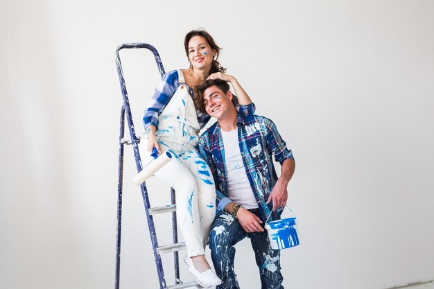 Funny young woman and man standing on the ladder.