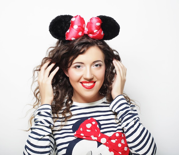 Funny young woman with mouse ears over white background