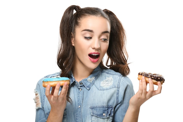 Funny young woman with tasty donuts on white background