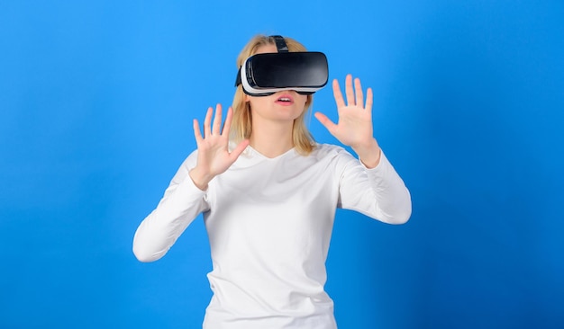 VR で面白い若い女性 スタジオで仮想現実のゴーグルを身に着けている美しい女性