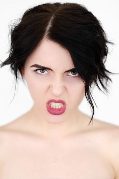 furious angry woman in rage baring the teeth on white wall.