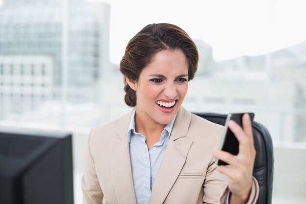 Furious businesswoman shouting at smartphone