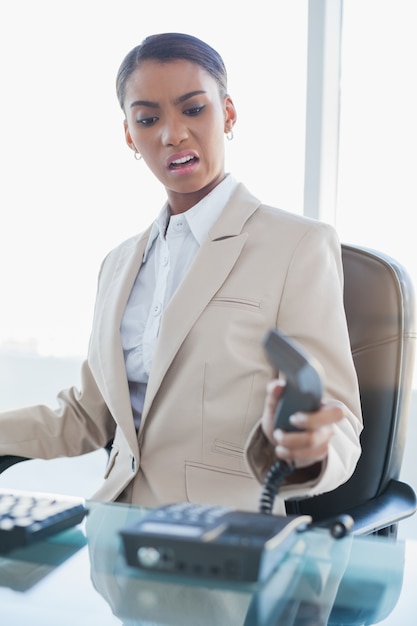 Furious elegant businesswoman hanging up the phone