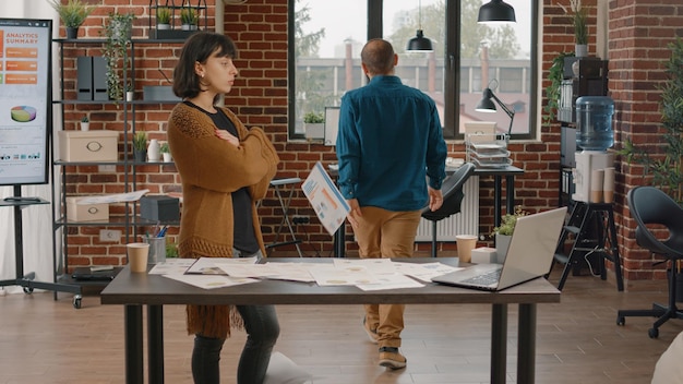 Furious man throwing chart papers in air after argument with\
woman in startup office. colleagues in conflict having quarrel and\
dispute while working on business project. workmates fighting