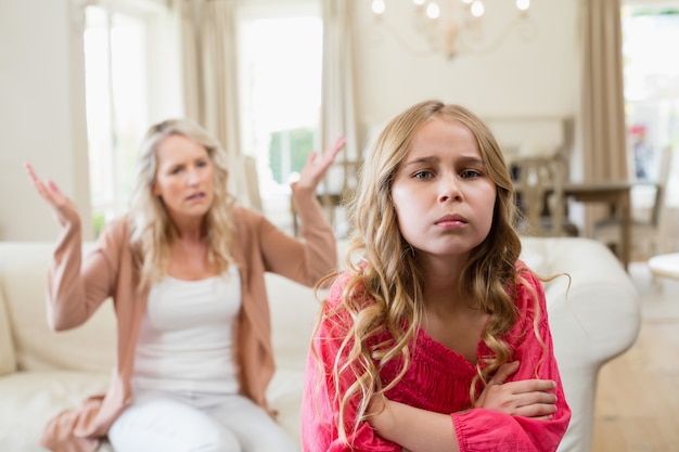 Furious mother arguing with her daughter in living room