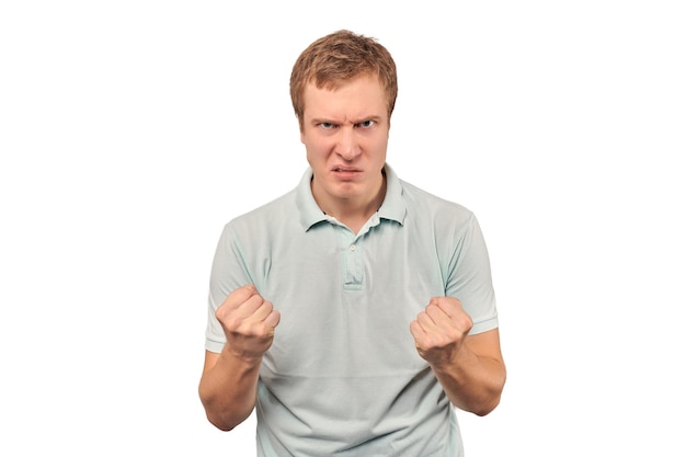 Furious young man in mint Tshirt ready to fight with fists isolated on white background