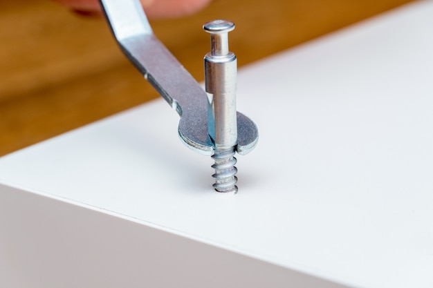 Furniture assembling process, screwing, tightening the bolt with a special wrench instrument