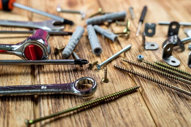 Furniture assembly tools set with screw dowel wrench and bolt on wooden table texture