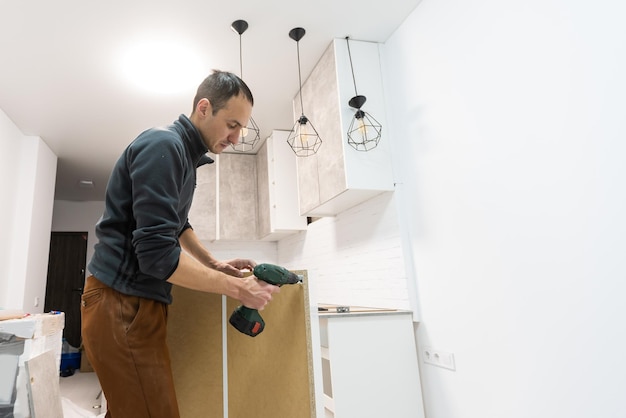 furniture assembly - worker installing cabinet shelf.