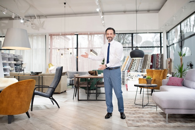 Furniture designer in tie and white shirt looking contented