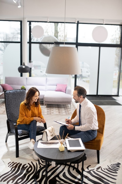 Furniture designer in tie and white shirt talking to the client