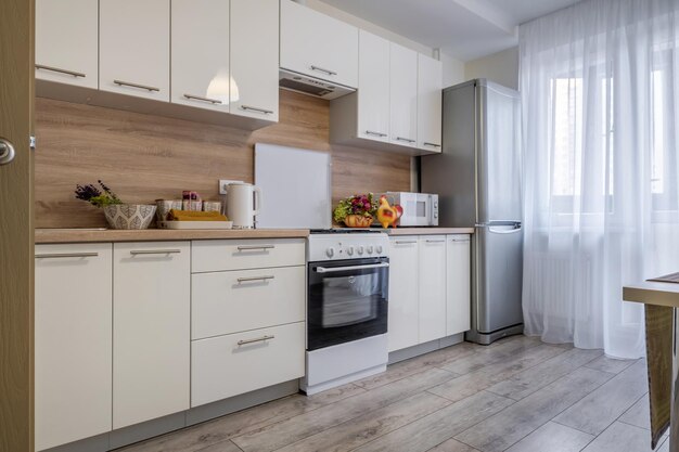 Furniture and utensils on modern luxure kitchen in studio apartments in minimalistic style with light color