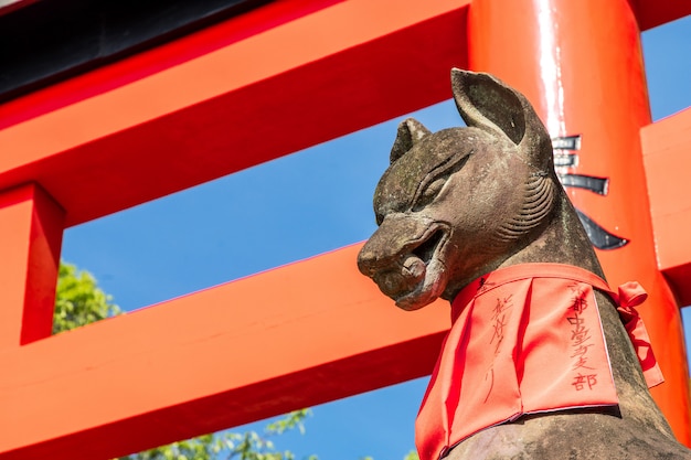 Fushimi inari stenen vos guarda houten poorten. Van vossen wordt aangenomen dat ze boodschappers van god zijn.