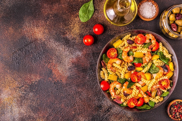 Fusili pasta salad with shrimps tomatoes peppers spinach olives