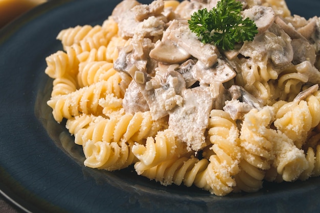 Fusilli pasta met champignons in roomsaus bovenaanzicht met ingrediënten op een houten tafel geen mensen