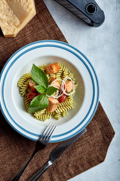 Fusilli-pasta met gebakken zalm en spinazie Het concept van de klassieke Italiaanse keuken Prachtig ingeblikte tafel met pasta