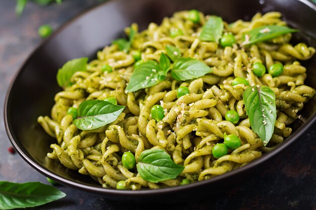 Fusilli pasta met pestosaus, doperwtjes en basilicum.