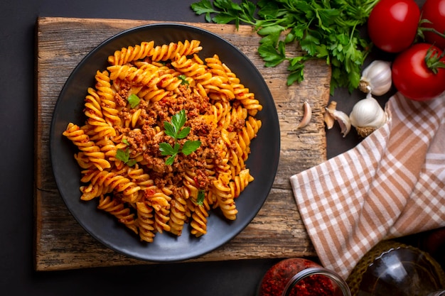 Паста фузилли, макароны по спирали или спирали с помидорами, соусом из фарша - стиль итальянской кухни