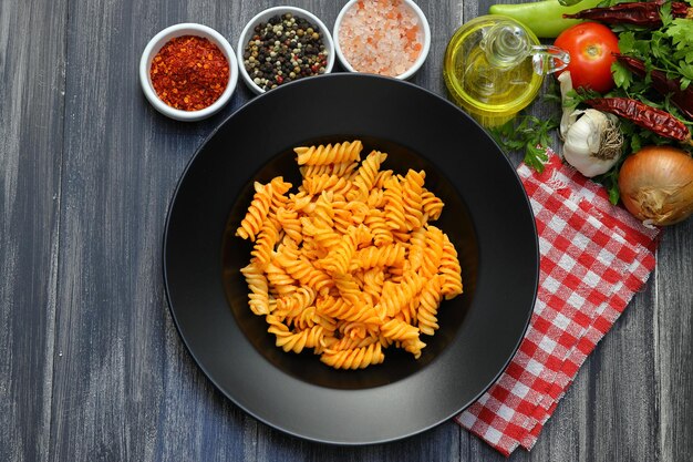 Fusilli pasta in tomato sauce gray background Italian food concept