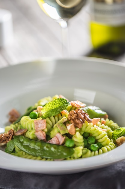 Fusilli pasta with green peas ham and walnuts. italian or mediterranean cuisine.