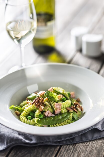 Fusilli pasta with green peas ham walnuts with white wine. italian or mediterranean cuisine.