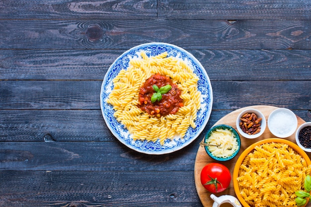 Fusilli pasta with tomato sauce, tomatoes, onion, garlic, dried paprika, olives, pepper and olive oil
