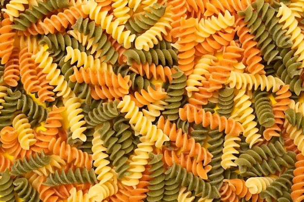 Fusilli pasta on yellow background Top view