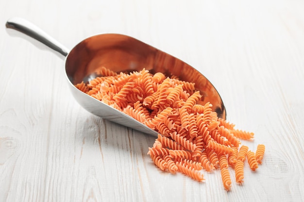 Fusilli red lentil pasta on a wooden background