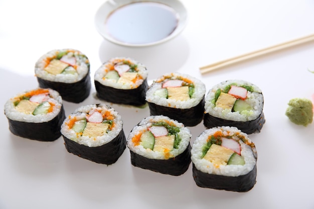 Футомаки суши, японский рулет, рисовое яйцо, авокадо, огурец и икра, изолированные на белом фоне