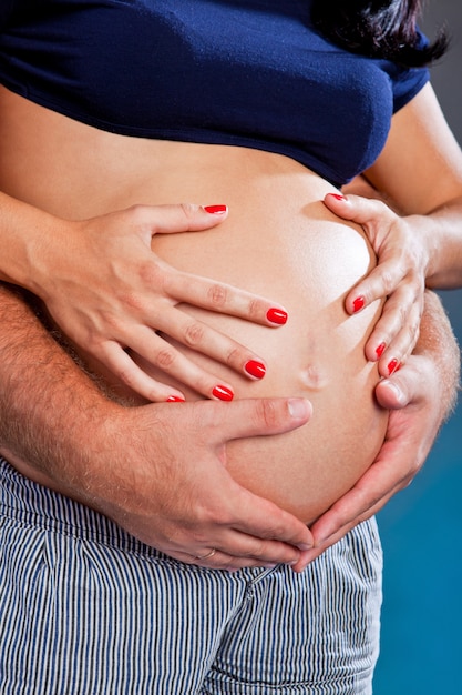 Future parents hold on the child, hands in the form of heart