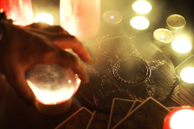 Photo future teller. mystic still life with voodoo doll, the tarot cards, books, evil candles and witchcraft objects. divination rite.