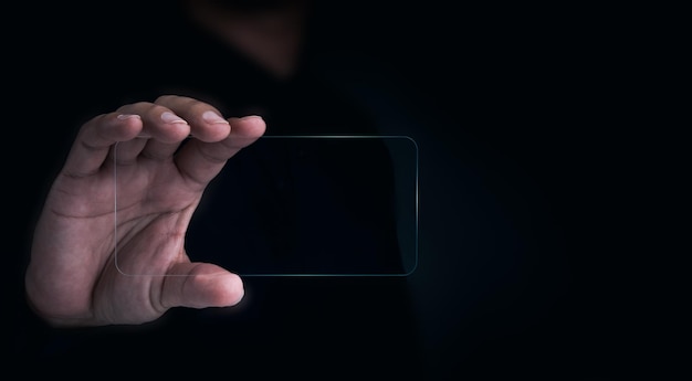 사진 미래의 투명 유리 전화 기술 모형 빈 화면 복사 공간이 있는 어둠 속에서 인간의 손에 있는 미래의 투명 스마트폰 수평 미래 기술 통신 장비