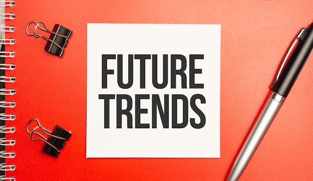 Future trends sign on sheet of paper on the red notepad with pen