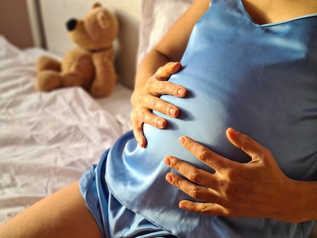 Future young mother puts palms on big belly