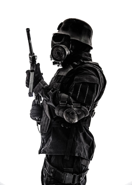 미래 지향적인 나치 군인 센티넬 방독면과 슈마이저 권총이 달린 강철 헬멧은 관심 프로필에 서 있는 흰색 스튜디오 샷에 격리되어 있습니다.