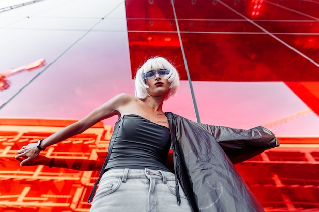 Futuristic style. Woman with glasses and near a red futuristic building.