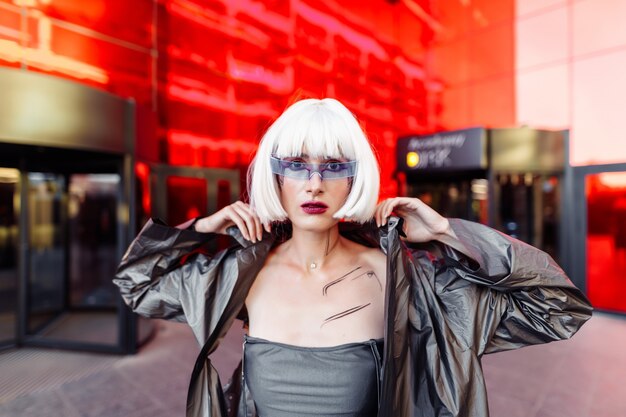 Futuristische stijl. Vrouw met bril en dichtbij een rood futuristisch gebouw.