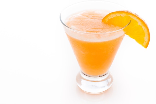 Fuzzy naval cocktail with orange wedge as a garnish.