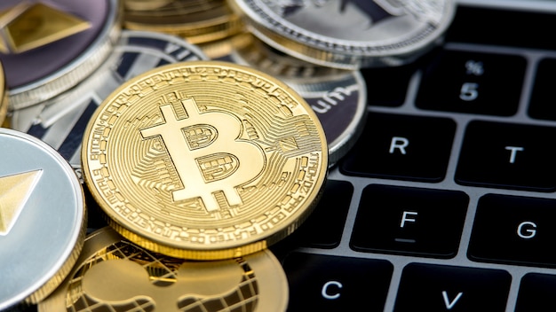 Fysieke metalen gouden bitcoin-valuta op het toetsenbord van de notebookcomputer. wereldwijd virtueel internetgeld. digitale muntcyberspace, cryptocurrency goud btc. investering online betaling