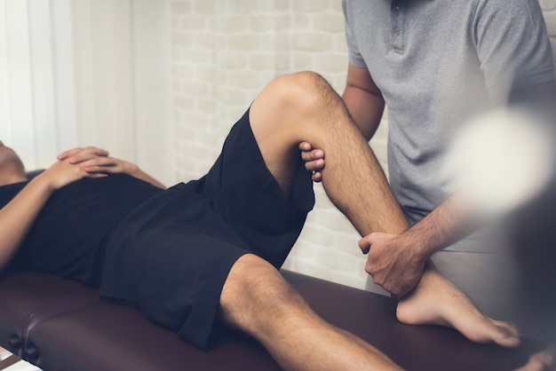 Foto fysiotherapeut die mannelijke mannelijke patiënt behandelen