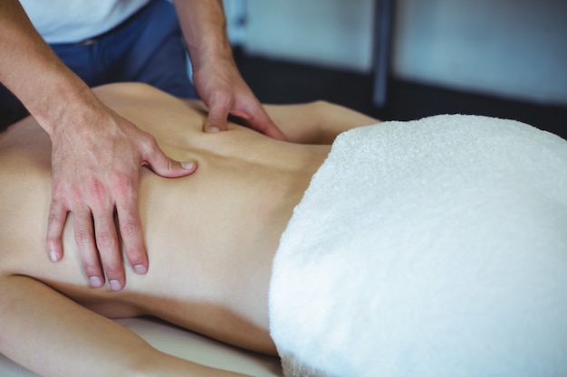 Fysiotherapeut die massage teruggeven aan een vrouw