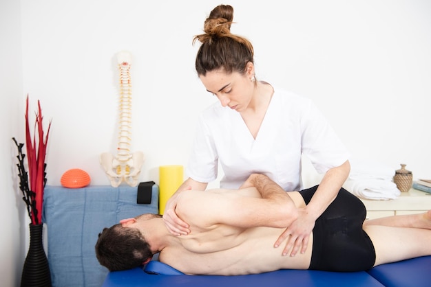 Fysiotherapeut die werkt aan de mobiliteit van de ruggengraat of dorsale wervelkolom van een patiënt.