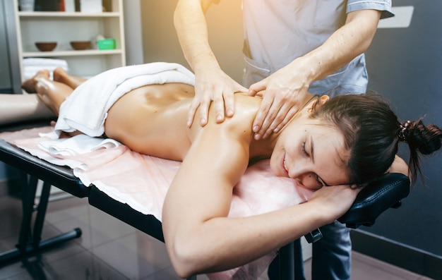 Fysiotherapeut massage geven aan een vrouw in de kliniek