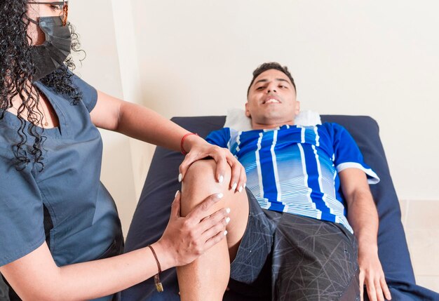 Fysiotherapeut vrouw die de knie van de patiënt controleert Orthopedisch specialist helpt een patiënt met een knieblessure knie fysiotherapie concept Knie revalidatie fysiotherapie